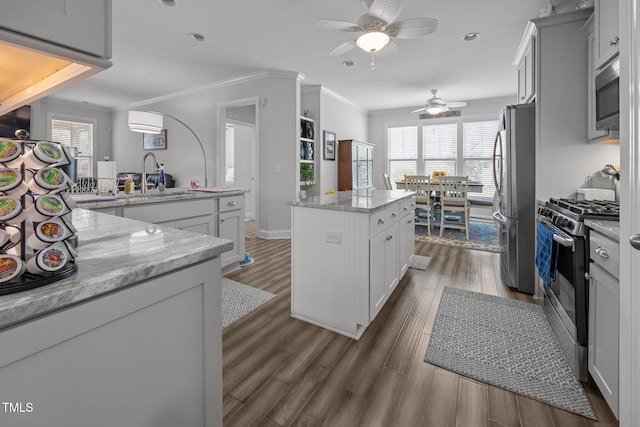 461 Cedar Pond Ct, Knightdale, NC 27545 - kitchen featuring stainless steel appliances, a ceiling fan, a sink, a kitchen island, and dark wood-style floors