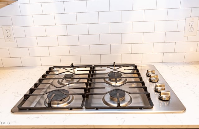1950 Menet St, Apex, NC 27502 - kitchen view of stainless steel gas cooktop, decorative backsplash, pot filler, and light stone countertops