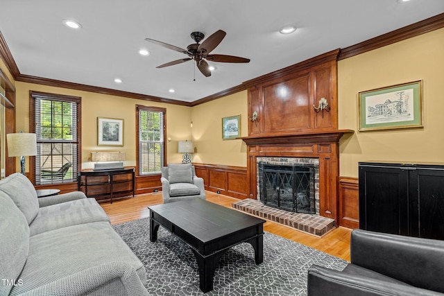 1501 Chatsworth Ln, Raleigh, NC 27614 - living area featuring ornamental molding, wainscoting, a ceiling fan, light wood finished floors, and a fireplace