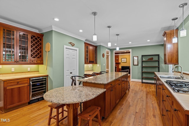 1501 Chatsworth Ln, Raleigh, NC 27614 - kitchen with beverage cooler, a sink, stainless steel gas stovetop, recessed lighting, and light wood-type flooring