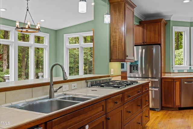 1501 Chatsworth Ln, Raleigh, NC 27614 - kitchen with appliances with stainless steel finishes, a sink, light countertops, decorative light fixtures, and brown cabinetry