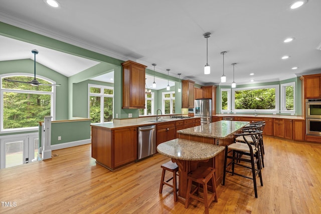 1501 Chatsworth Ln, Raleigh, NC 27614 - kitchen with appliances with stainless steel finishes, brown cabinets, a kitchen island, ornamental molding, and recessed lighting