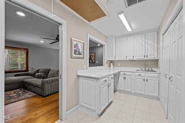 1501 Chatsworth Ln, Raleigh, NC 27614 - kitchen with a sink, white cabinetry, light countertops, light tile patterned floors, and open floor plan