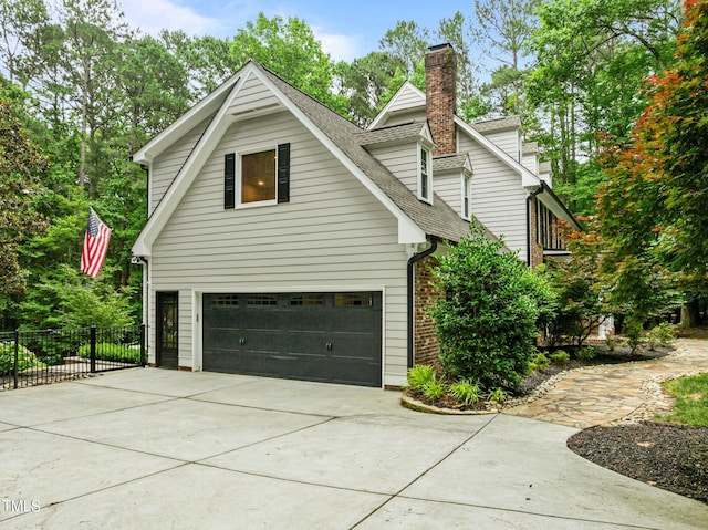 1501 Chatsworth Ln, Raleigh, NC 27614 - view of home's exterior with a shingled roof, concrete driveway, an attached garage, a chimney, and brick siding