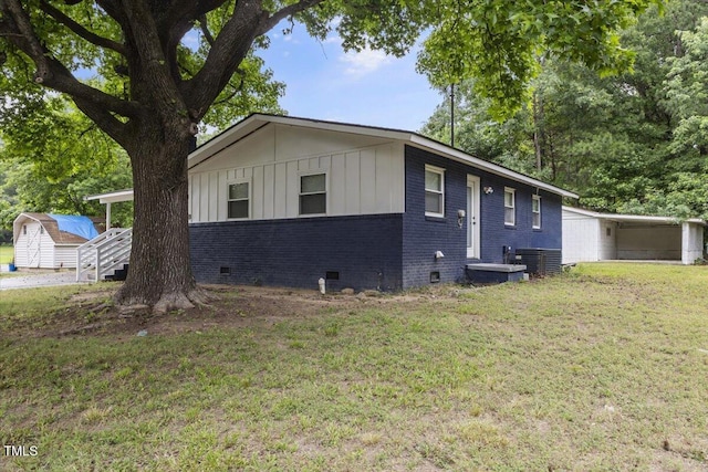 2752 Weldon Ter, Durham, NC 27703 - view of front of property with brick siding, a front yard, crawl space, board and batten siding, and central air condition unit