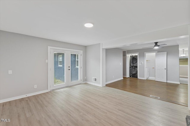 2752 Weldon Ter, Durham, NC 27703 - unfurnished living room with estacked washer and dryer, wood finished floors, french doors, baseboards, and a ceiling fan