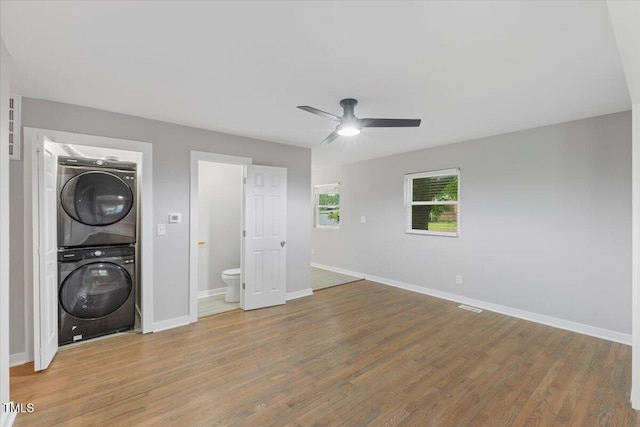 2752 Weldon Ter, Durham, NC 27703 - washroom with stacked washer and clothes dryer, ceiling fan, wood finished floors, and baseboards