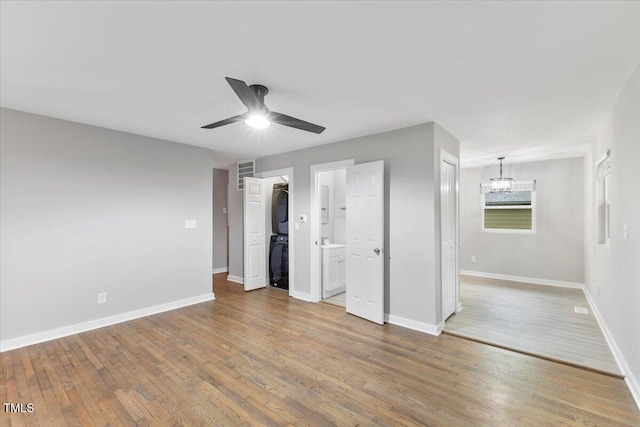 2752 Weldon Ter, Durham, NC 27703 - unfurnished bedroom featuring stacked washer / drying machine, wood finished floors, baseboards, ensuite bath, and a ceiling fan