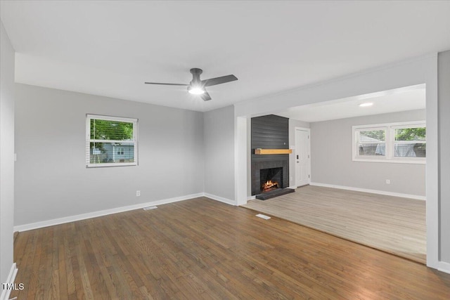 2752 Weldon Ter, Durham, NC 27703 - unfurnished living room with a brick fireplace, wood finished floors, a ceiling fan, and baseboards