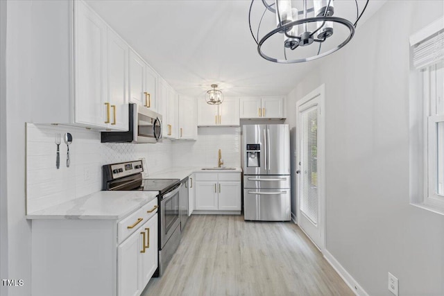 2752 Weldon Ter, Durham, NC 27703 - kitchen with appliances with stainless steel finishes, a sink, a chandelier, and backsplash