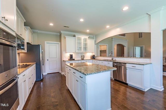 367 Tayside St, Clayton, NC 27520 - kitchen featuring stainless steel appliances, arched walkways, white cabinets, crown molding, and tasteful backsplash