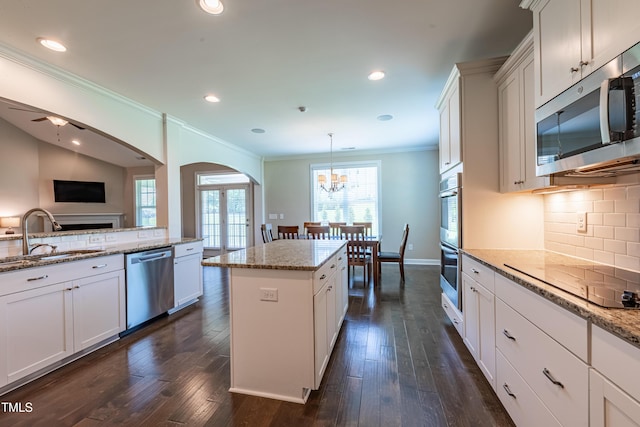 367 Tayside St, Clayton, NC 27520 - kitchen with appliances with stainless steel finishes, a sink, ornamental molding, arched walkways, and decorative backsplash