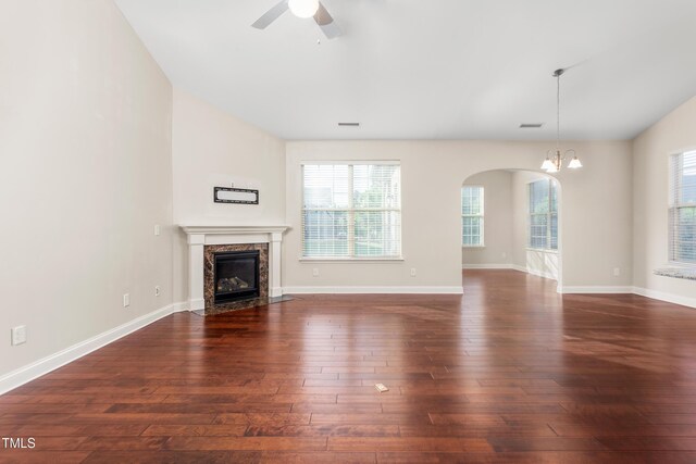 4110 Argyle Trl, Burlington, NC 27215 - unfurnished living room with a fireplace, dark wood-style flooring, a ceiling fan, a chandelier, and healthy amount of natural light