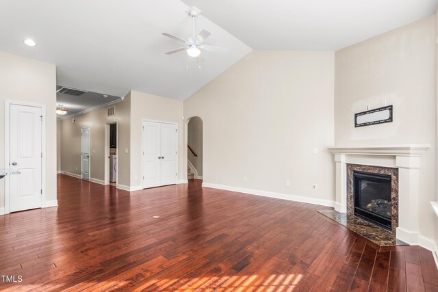 4110 Argyle Trl, Burlington, NC 27215 - unfurnished living room featuring a ceiling fan, a premium fireplace, wood-type flooring, arched walkways, and vaulted ceiling