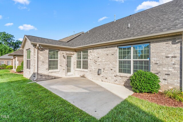 4110 Argyle Trl, Burlington, NC 27215 - back of house featuring a yard, brick siding, a patio, and roof with shingles
