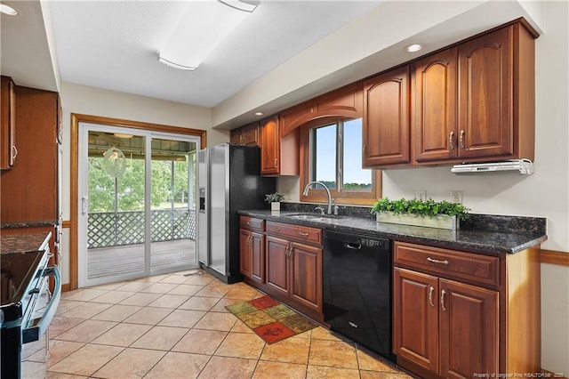 38 E Lndg, Sanford, NC 27332 - kitchen featuring appliances with stainless steel finishes, a sink, dark stone countertops, light tile patterned flooring, and recessed lighting