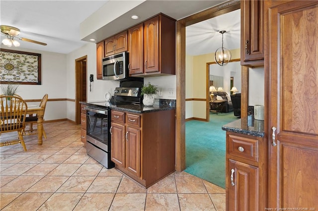 38 E Lndg, Sanford, NC 27332 - kitchen with stainless steel appliances, brown cabinets, ceiling fan, baseboards, and a chandelier