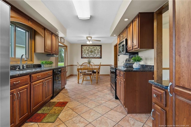 38 E Lndg, Sanford, NC 27332 - kitchen featuring appliances with stainless steel finishes, a sink, ceiling fan, light tile patterned floors, and dark stone countertops