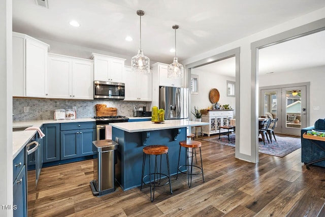 290 Quarter Gate Trce, Chapel Hill, NC 27516 - kitchen with stainless steel appliances, blue cabinetry, dark wood-type flooring, a kitchen breakfast bar, and recessed lighting