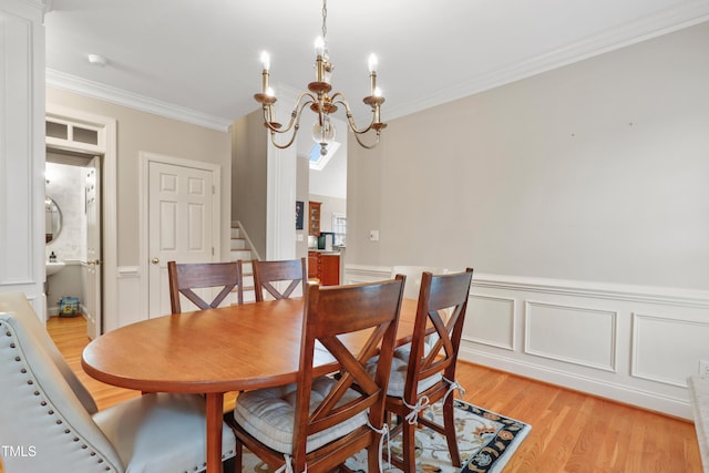 327 Commons Walk Cir, Cary, NC 27519 - dining area with a chandelier, crown molding, light wood-type flooring, stairway, and wainscoting