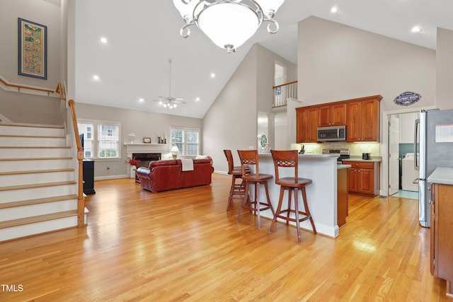 327 Commons Walk Cir, Cary, NC 27519 - kitchen with stainless steel appliances, high vaulted ceiling, light countertops, a breakfast bar, and open floor plan