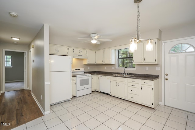 2012 Stadium Dr, Durham, NC 27705 - kitchen with white appliances, under cabinet range hood, a sink, dark countertops, and white cabinets