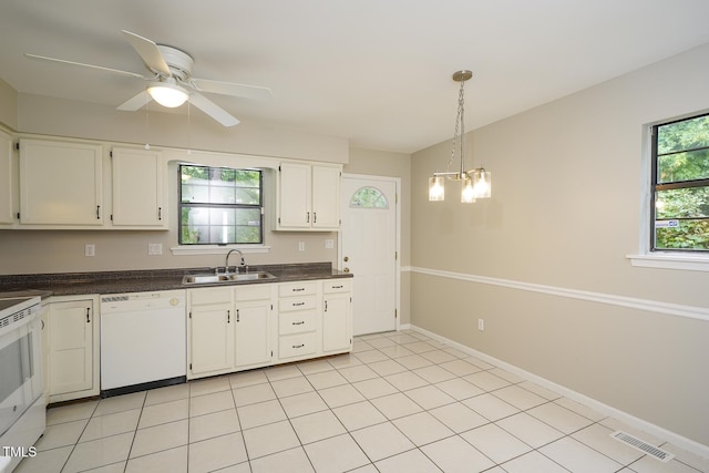 2012 Stadium Dr, Durham, NC 27705 - kitchen with white appliances, a sink, dark countertops, white cabinets, and hanging light fixtures