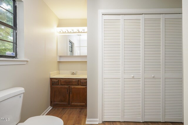 2012 Stadium Dr, Durham, NC 27705 - half bath with a closet, toilet, vanity, wood finished floors, and baseboards