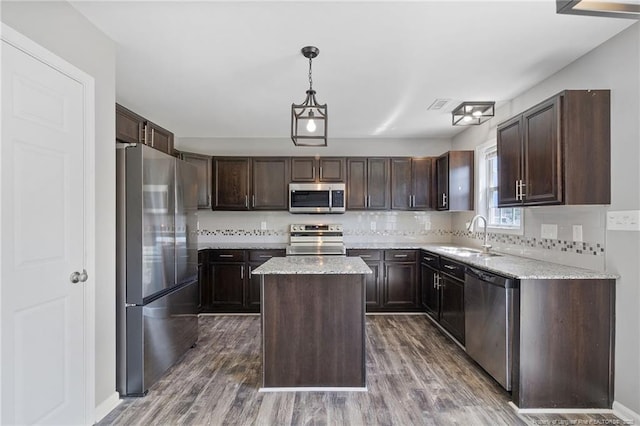 406 Broad Dr, Raeford, NC 28376 - kitchen featuring stainless steel appliances, a sink, a kitchen island, dark brown cabinetry, and decorative backsplash