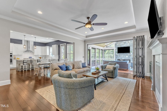 1716 Arberdour Dr, Apex, NC 27502 - living room with a tray ceiling, a fireplace, a ceiling fan, wood-type flooring, and baseboards