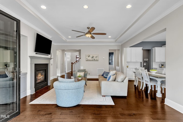 1716 Arberdour Dr, Apex, NC 27502 - living room with a glass covered fireplace, dark wood finished floors, ceiling fan, stairs, and recessed lighting