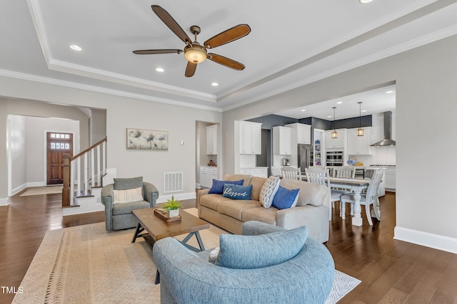 1716 Arberdour Dr, Apex, NC 27502 - living room with dark wood-style flooring, ceiling fan, baseboards, stairway, and crown molding