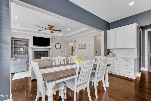1716 Arberdour Dr, Apex, NC 27502 - dining space with recessed lighting, dark wood-type flooring, a ceiling fan, crown molding, and a glass covered fireplace