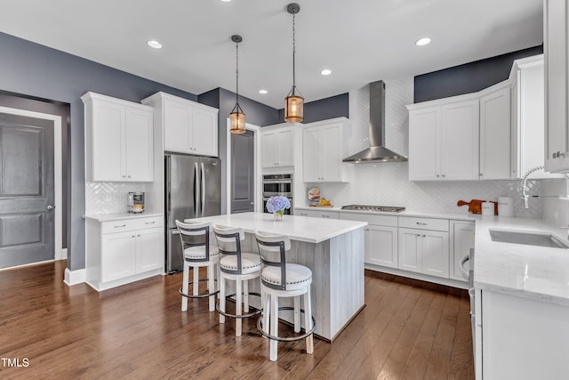1716 Arberdour Dr, Apex, NC 27502 - kitchen featuring appliances with stainless steel finishes, wall chimney exhaust hood, a sink, white cabinets, and recessed lighting