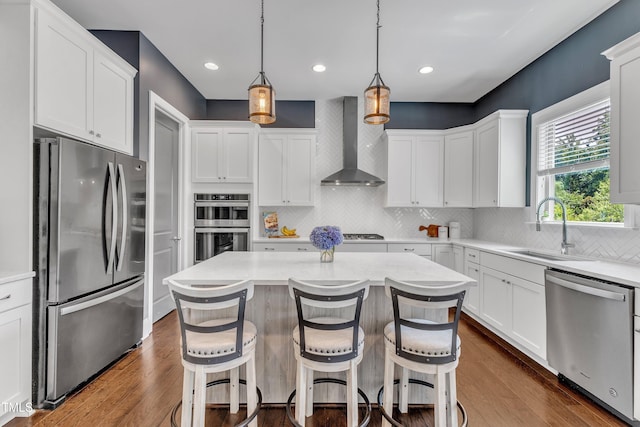 1716 Arberdour Dr, Apex, NC 27502 - kitchen featuring stainless steel appliances, wall chimney range hood, a sink, white cabinetry, and recessed lighting