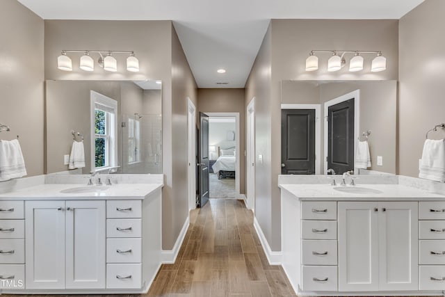 1716 Arberdour Dr, Apex, NC 27502 - bathroom with ensuite bathroom, a stall shower, two vanities, and wood finished floors