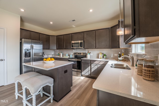 140 Enfield Dr, Carthage, NC 28327 - kitchen with stainless steel appliances, a sink, dark brown cabinets, a center island, and decorative backsplash