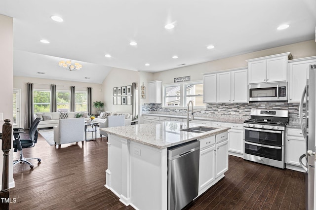 105 Putters Ct, Durham, NC 27703 - kitchen featuring stainless steel appliances, open floor plan, backsplash, white cabinets, and lofted ceiling