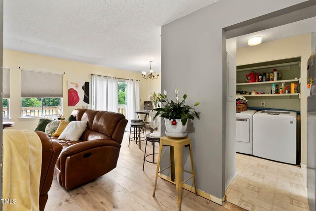 5931 Farm Gate Rd, Raleigh, NC 27606 - living area featuring washing machine and dryer, a chandelier, a textured ceiling, and light wood finished floors