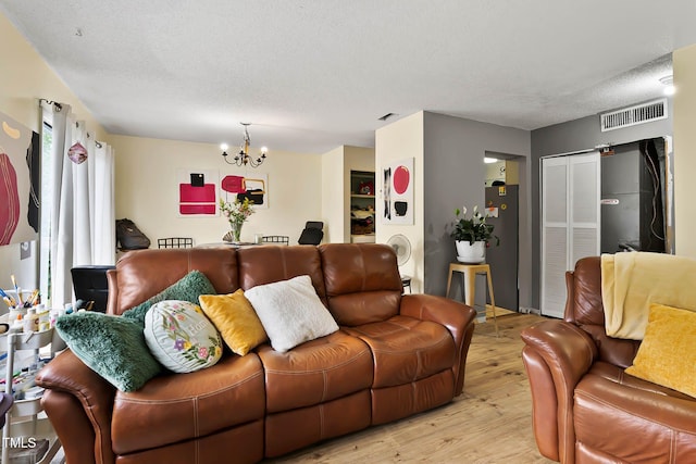 5931 Farm Gate Rd, Raleigh, NC 27606 - living room featuring a chandelier, light wood finished floors, and a textured ceiling