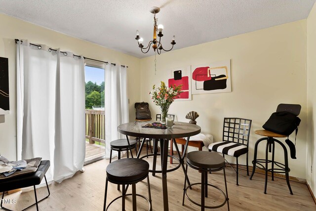 5931 Farm Gate Rd, Raleigh, NC 27606 - dining area featuring a chandelier, a textured ceiling, and wood finished floors