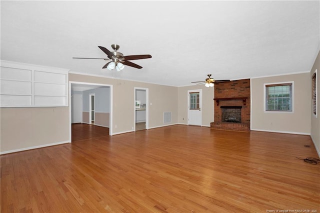 687 Blawell St, Stedman, NC 28391 - unfurnished living room with ceiling fan, light wood-style floors, a brick fireplace, baseboards, and ornamental molding