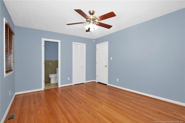687 Blawell St, Stedman, NC 28391 - unfurnished bedroom featuring baseboards, wood finished floors, ensuite bath, and a ceiling fan