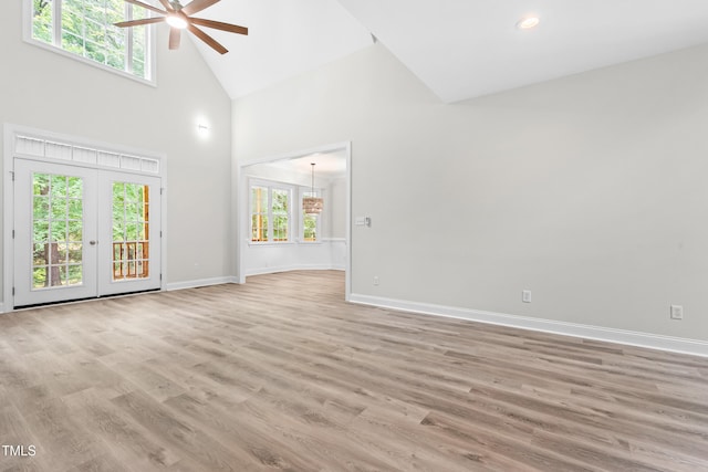 2015 Saddlebrook Dr, Archer Lodge, NC 27527 - unfurnished living room with a ceiling fan, high vaulted ceiling, baseboards, light wood finished floors, and a chandelier