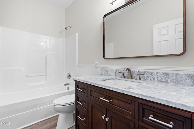 2015 Saddlebrook Dr, Archer Lodge, NC 27527 - full bathroom with vanity, toilet, shower / bath combination, wood finished floors, and a wainscoted wall