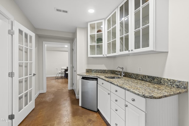 704 Walcott Way, Cary, NC 27519 - kitchen with dishwasher, a sink, finished concrete floors, white cabinets, and glass insert cabinets