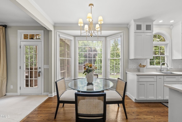 704 Walcott Way, Cary, NC 27519 - dining room featuring a chandelier, crown molding, baseboards, and wood finished floors