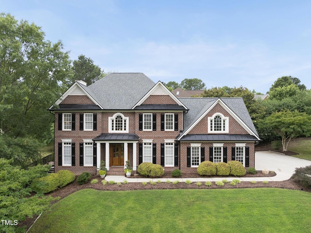 704 Walcott Way, Cary, NC 27519 - colonial home featuring brick siding, a front yard, and a standing seam roof