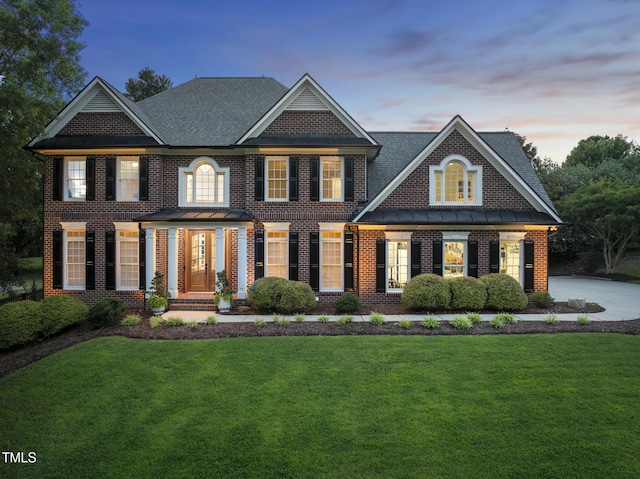 704 Walcott Way, Cary, NC 27519 - georgian-style home with a front lawn, brick siding, a standing seam roof, and a shingled roof
