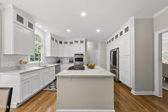 704 Walcott Way, Cary, NC 27519 - kitchen featuring appliances with stainless steel finishes, a sink, crown molding, a center island, and dark wood finished floors